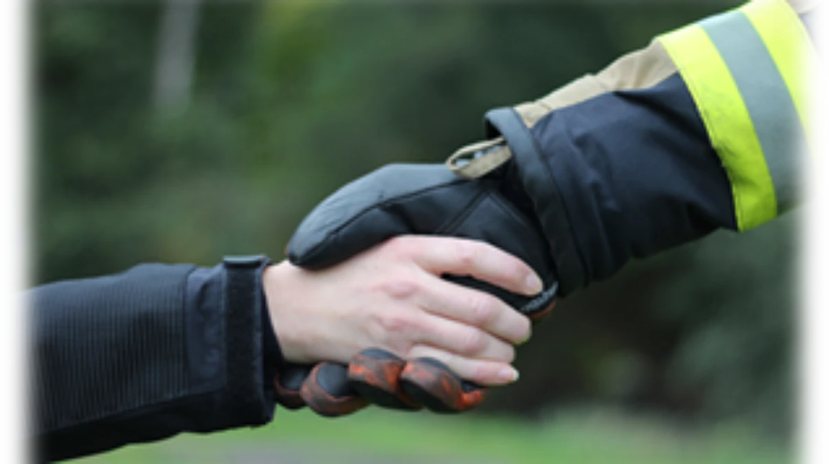 Räddningstjänstpersonal skakar hand med individ