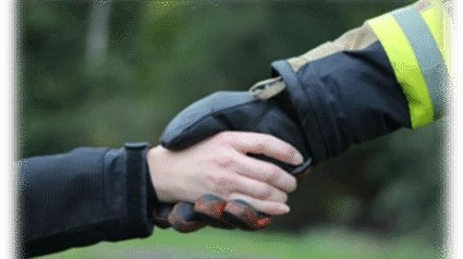 Räddningstjänstpersonal skakar hand med individ