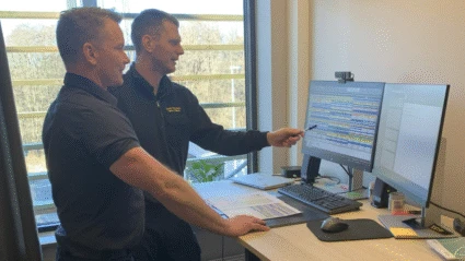 Två kollegor pratar vid en dator