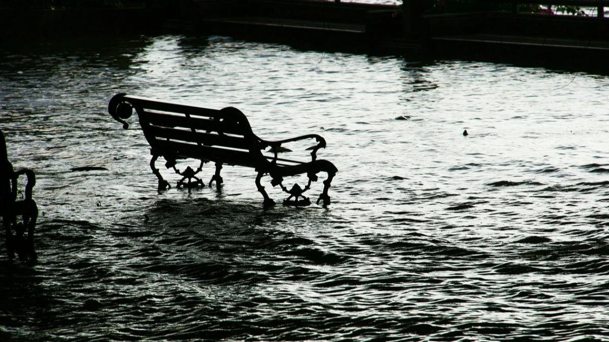 En parkbänk i högt vatten vid översvämning