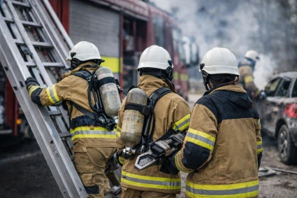 Tre brandmäns ryggar mot kameran